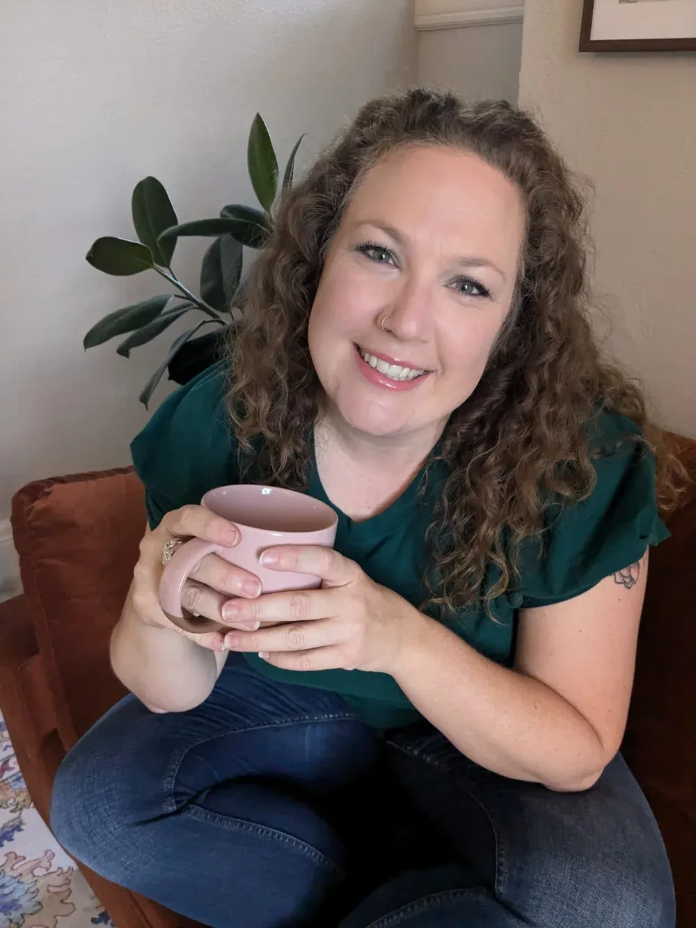 Katie Fortunato smiling with a coffee mug in her office